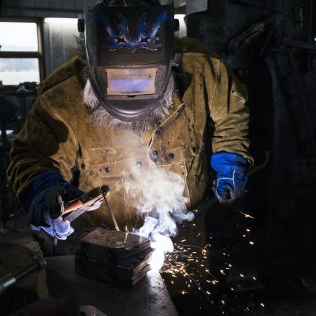 blacksmith-in-welding-mask-welding-metal-in-workshop.jpg